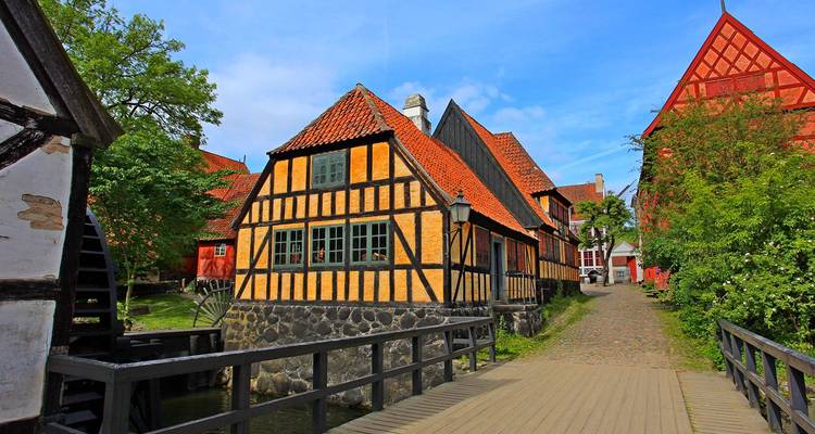 Maison jaune à colombages avec toit de tuiles rouges dans les rues du musée en plein air d'Aarhus.