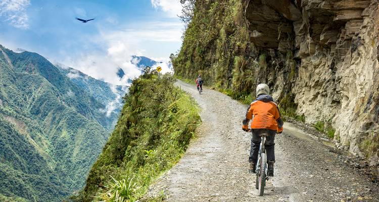 Cyclistes sur un sentier de montagne étroit avec un environnement luxuriant
