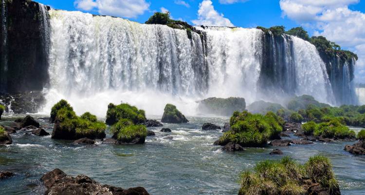 Der breite Vorhang der Iguazu-Fälle stürzt inmitten üppigen Grüns in den Fluss.