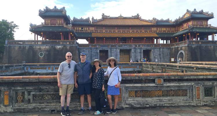 Small family group poses in front of the historic Imperial Citadel gate in Hue.