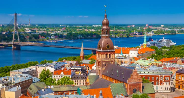 Stadtlandschaft mit einer hohen Kathedrale und einem Fluss im Hintergrund.
