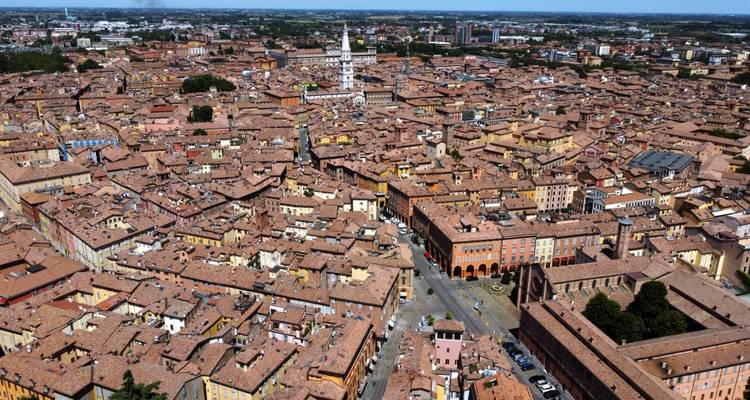 Aerial view of Modena, Italy with terracotta rooftops and central tower.