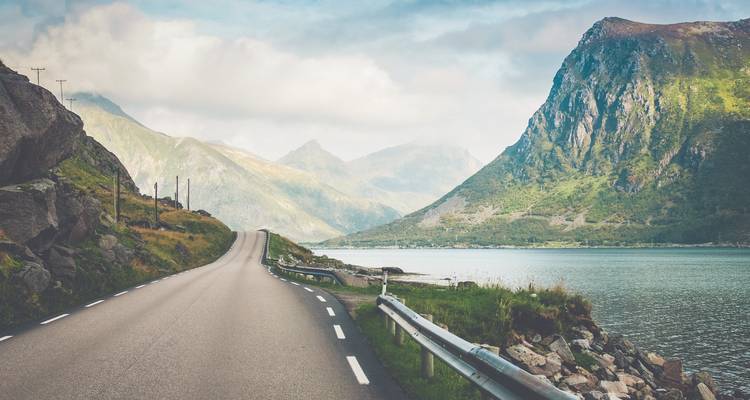 Malerische Küstenstraße mit hohen Bergen und einem Fjord.