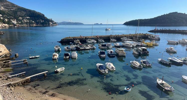 Petit port avec des bateaux et une eau bleue claire.
