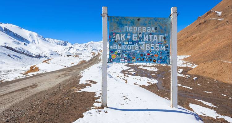 Signpost in a snowy mountain pass.