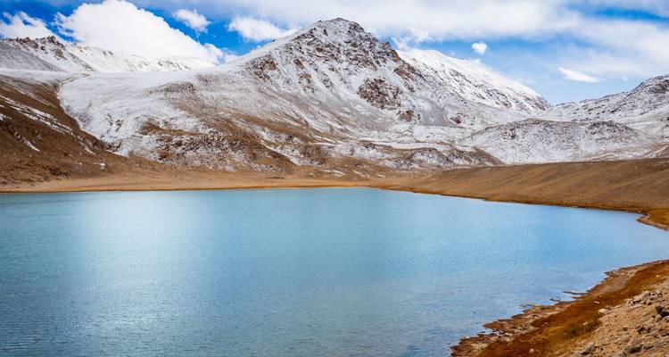 Mountain lake surrounded by snow-covered peaks.