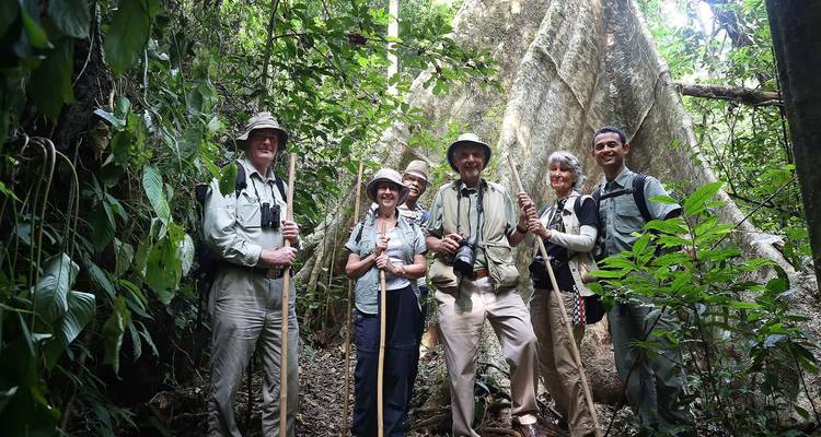 Groupe posant pour une photo dans une jungle avec des bâtons de randonnée.