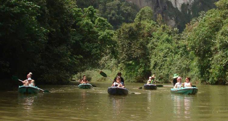 Kayak en groupe sur une rivière calme entourée de jungle.