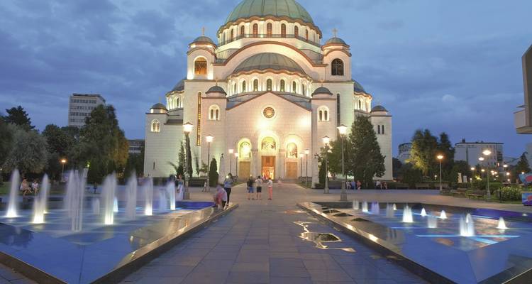 Église avec fontaines au crépuscule.