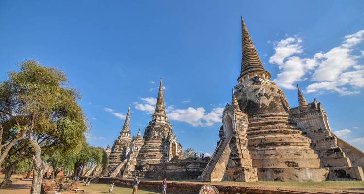 Tall ancient chedis of Ayutthaya reach into a cloudless blue sky.