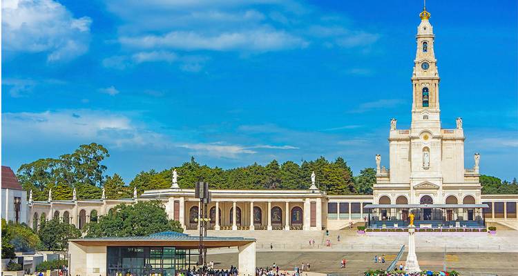 De indrukwekkende Basiliek van Fátima torent uit boven een uitgestrekt plein vol met pelgrims.