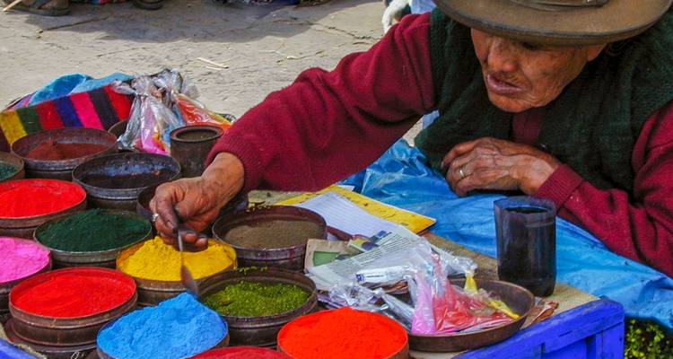 An artisan working with colorful pigments in bowls.