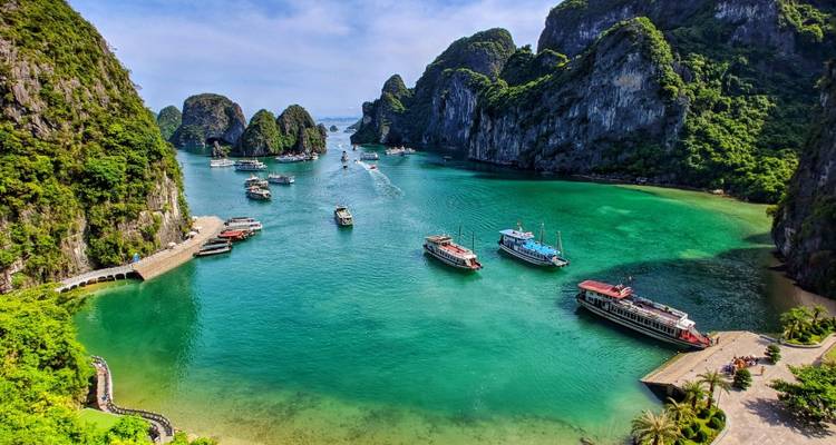 Baie d'Halong avec des bateaux et des îles calcaires imposantes.