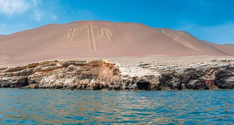 Küstenlandschaft mit einer großen Geoglyphe im Sand.