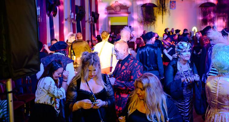 Des personnes en costumes socialisant dans une pièce décorée.