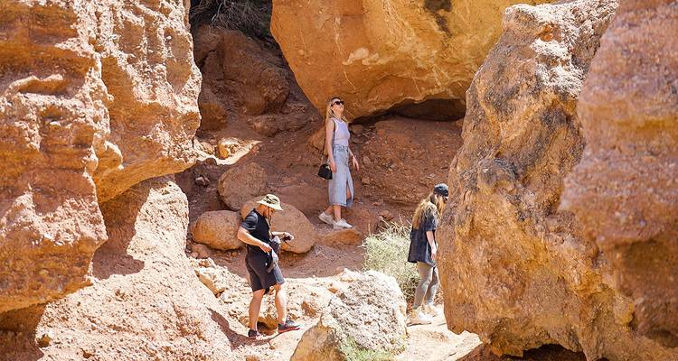 Hikers exploring a canyon with large rock formations.