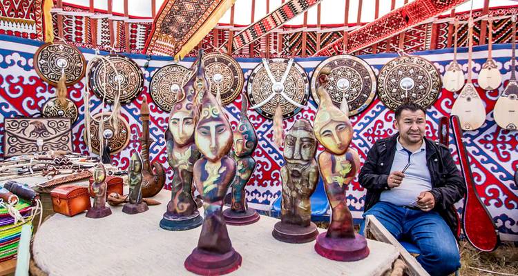 Traditional market scene with cultural artifacts and a person sitting.