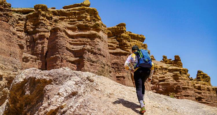 Person hiking on a rocky path in a canyon.