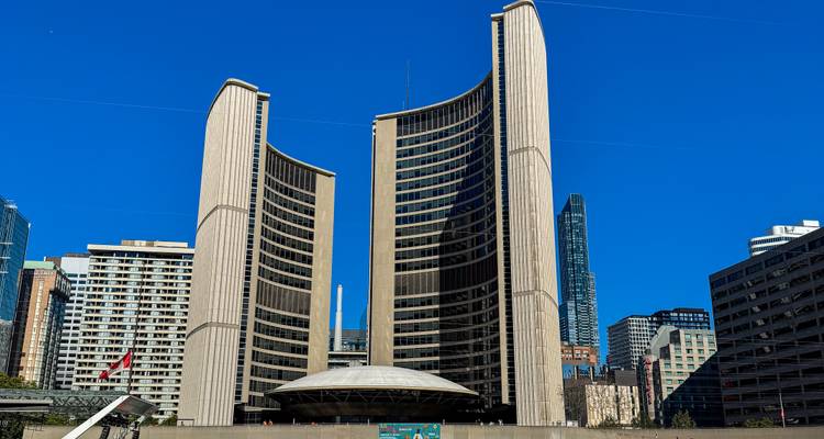 Las gemelas torres curvas del Ayuntamiento de Toronto se alzan contra un cielo azul cobalto impecable.