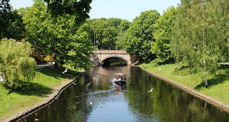 Kanalszene mit einem Boot und alter Brücke.