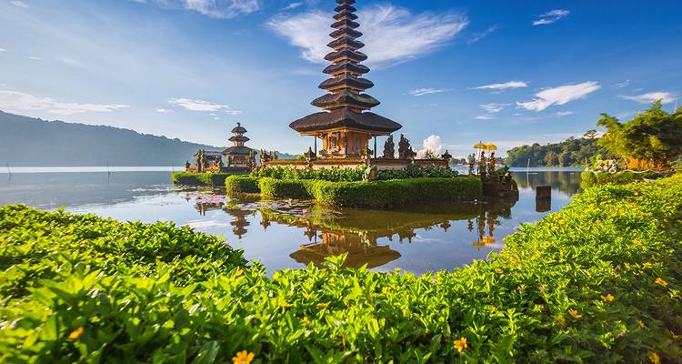 Temple architecture surrounded by water and lush greenery.