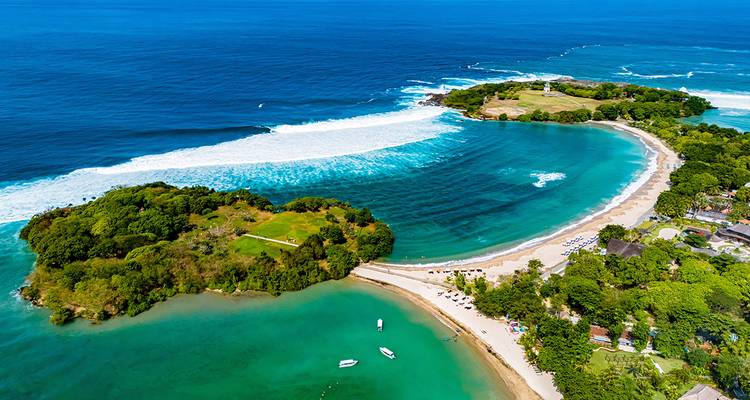 Aerial view of a tranquil beach and clear blue waters.