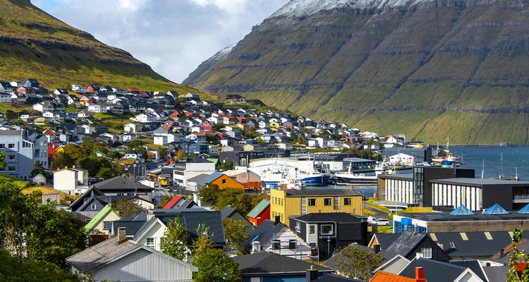 Un pueblo pintoresco en las Islas Feroe con casas coloridas y terreno montañoso.