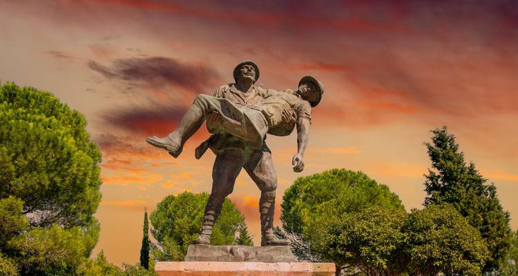 Statue of a soldier in a dramatic sky.