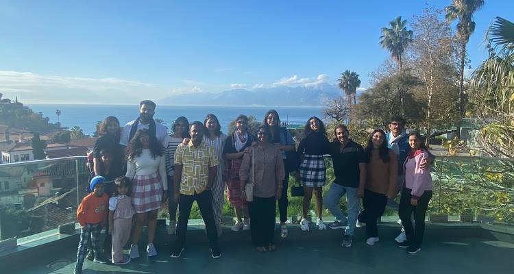 Groep mensen die poseren met een schilderachtige achtergrond met uitzicht op zee.