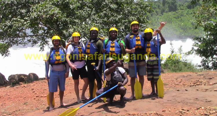 Groupe de personnes en casques et gilets de sauvetage posant avant le rafting.