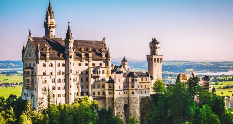 Neuschwanstein Castle surrounded by lush green landscape.