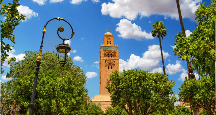 Le minaret saisissant de la mosquée Koutoubia entouré d'une végétation luxuriante.