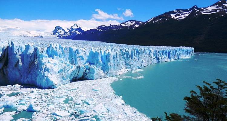 Panoramic view of a massive glacier meeting a turquoise lake.