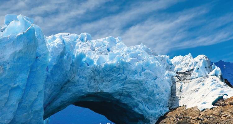 Massive ice arch formation of a glacier with a clear sky.