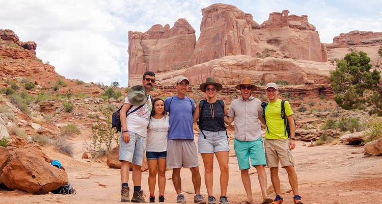 Groep mensen die poseren met een canyon op de achtergrond.