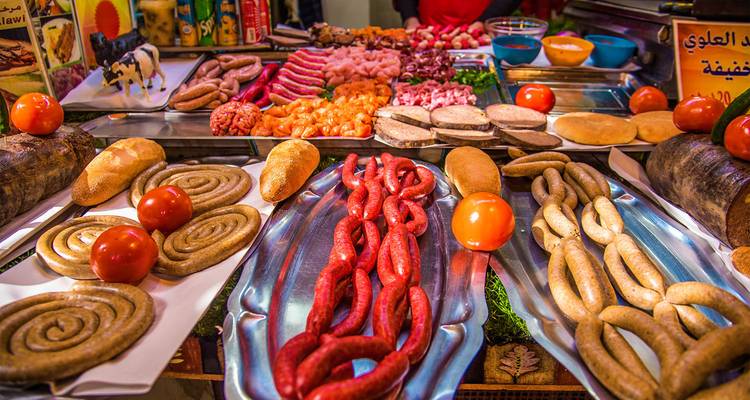 Colorful display of meats, sausages and vegetables at a Moroccan street food stall.