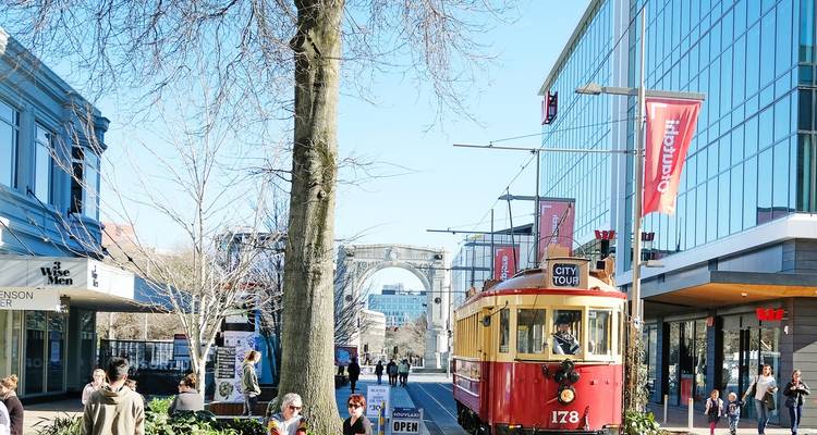 A city tram passing through a bustling street.