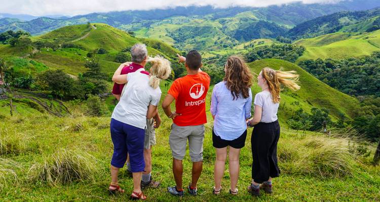 Group of hikers enjoying a view of green hills.