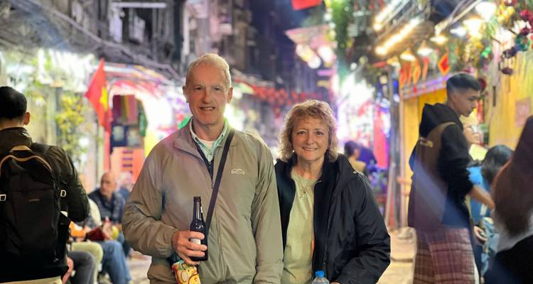 Un couple pose dans le marché nocturne coloré du Vieux Quartier de Hanoï rempli de lanternes et de foules floues