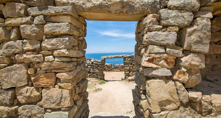 Structure de pierre ancienne avec vue sur le ciel et l'eau en arrière-plan.