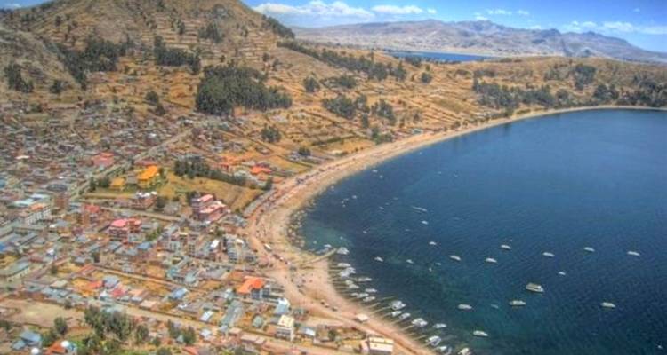 Vista aérea de un pueblo costero con montañas al fondo