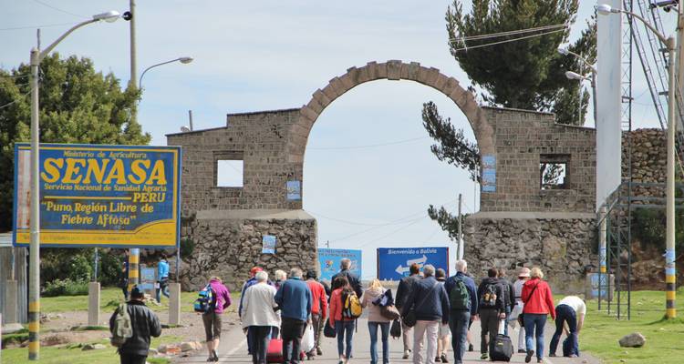 Grupo caminando hacia un arco de piedra con letreros
