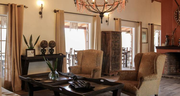 Un salon confortable avec des fauteuils et une décoration murale.