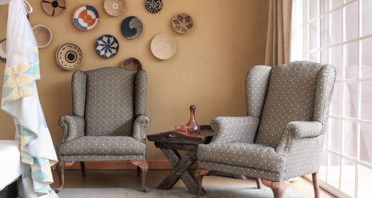 Une pièce avec des chaises décoratives et de l'art mural.