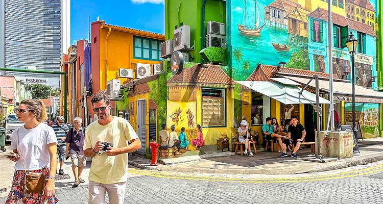 Kleurrijke muurschilderingen en mensen die lopen op een levendige straat in Singapore.