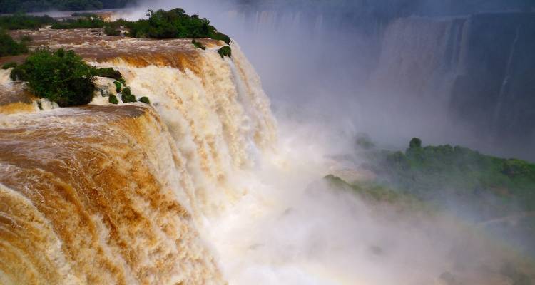 Close view of powerful Iguazu Falls with brown waters.
