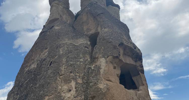 Natuurlijke rotsformaties met openingen in een heldere blauwe lucht.