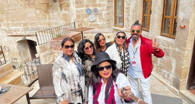 Groep mensen die een selfie maken in een historische gebouwomgeving.