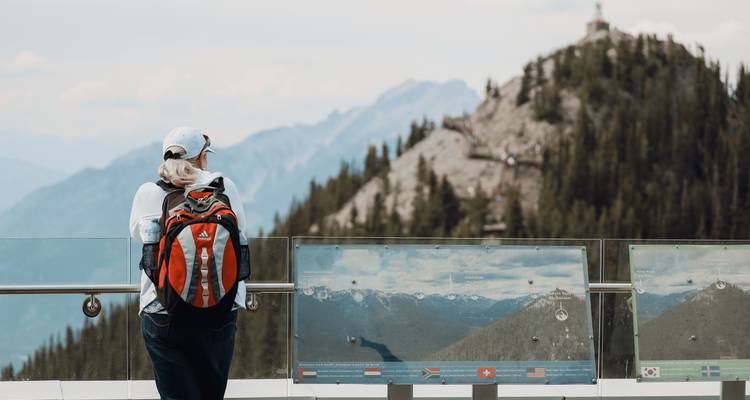 Persoon met rugzak die bergachtig landschap bekijkt.