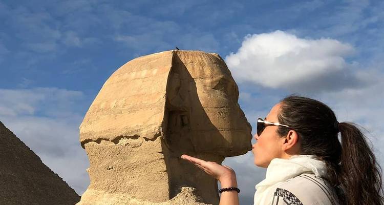Person playfully posing with Sphinx in the background.